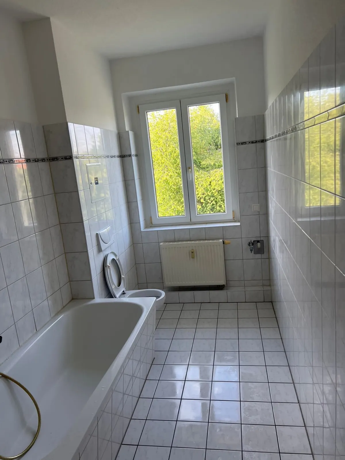 Leeres, besenrein geräumtes Badezimmer mit weisser Wanne nach der Haushaltsauflösung, bereit zur Übergabe